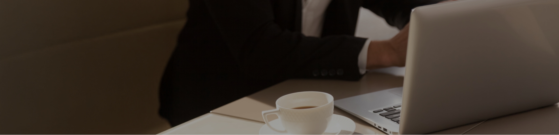 Recruiter arbeitet am Laptop im Büro mit Kaffee am Arbeitsplatz